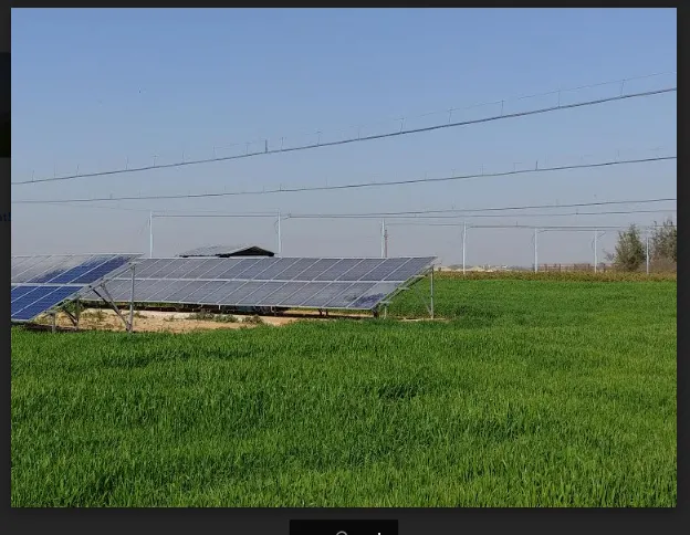 Solar panels powering a Floppy Sprinkler system over a green field